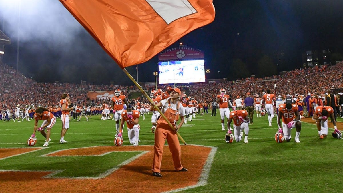 Clemson players kneel in end zone of Memorial Stadium prior to a game