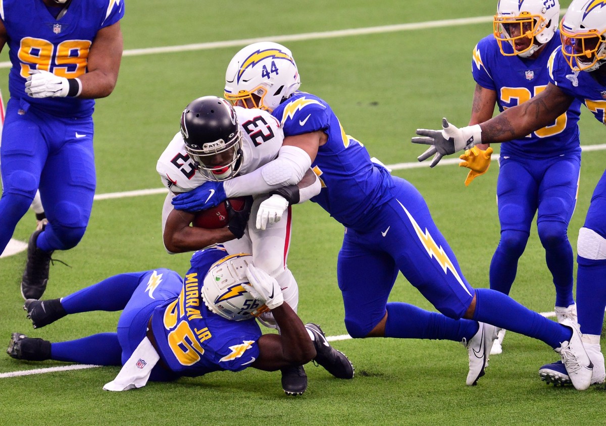 Dec 13, 2020; Inglewood, California, USA; Atlanta Falcons running back Brian Hill (23) is brought down by Los Angeles Chargers outside linebacker Kyzir White (44) and outside linebacker Kenneth Murray (56) during the second half at SoFi Stadium.