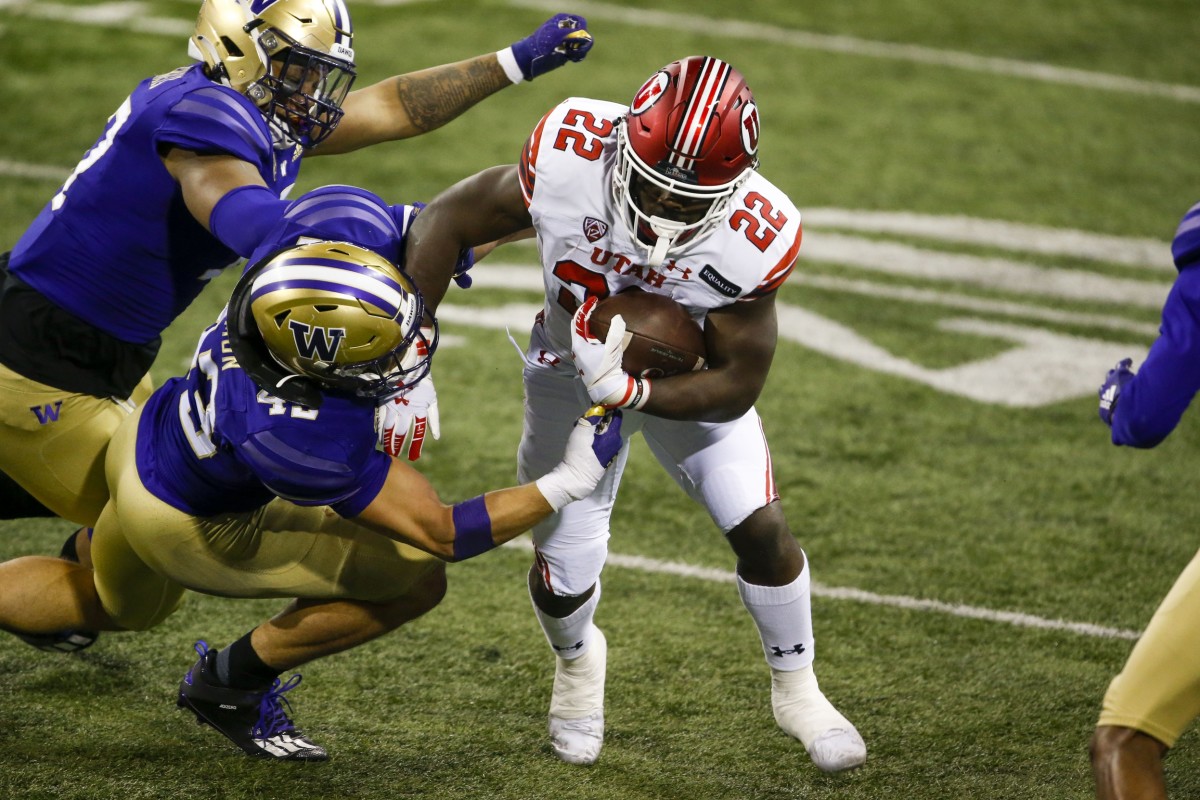 Nov 28, 2020; Seattle, Washington, USA; Utah Utes running back Ty Jordan (22) rushes against Washington Huskies linebacker Jackson Sirmon (43) and linebacker Sav'ell Smalls (17) during the first quarter at Alaska Airlines Field at Husky Stadium.