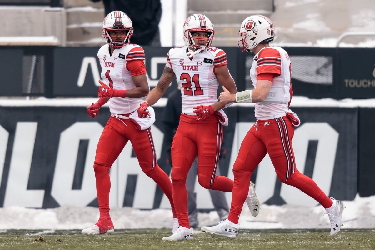 Dec 12, 2020; Boulder, Colorado, USA; Utah Utes wide receiver Solomon Enis (21) celebrates his touchdown with quarterback Jake Bentley (8) and wide receiver Bryan Thompson (1) in the first quarter against the Colorado Buffaloes at Folsom Field.