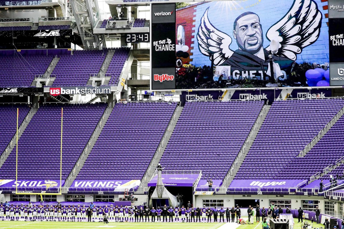 A mural of George Floyd on the video screen and a stadium full of empty seats at the Vikings' season opener