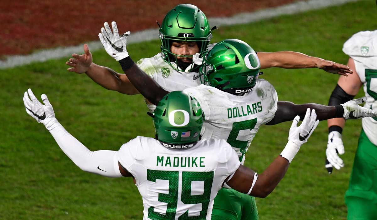 Oregon Ducks running back Travis Dye (26) celebrates scoring a touchdown in the third quarter with Oregon Ducks defensive end Kayvon Thibodeaux (5) and Oregon Ducks linebacker MJ Cunningham