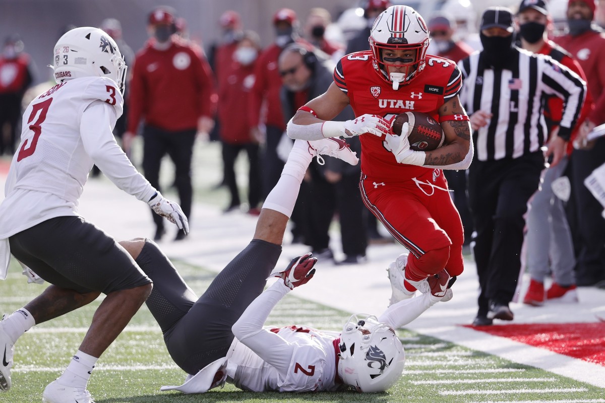 Dec 19, 2020; Salt Lake City, Utah, USA; Utah Utes running back Micah Bernard (3) runs the ball against Washington State Cougars defensive back Daniel Isom (3) and Washington State Cougars defensive back Derrick Langford (2) in the third quarter at Rice-Eccles Stadium.