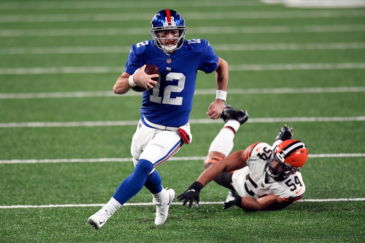New York Giants quarterback Colt McCoy (12) breaks a tackle by Cleveland Browns defensive end Olivier Vernon (54) during a game at MetLife Stadium on Sunday, December 20, 2020, in East Rutherford.