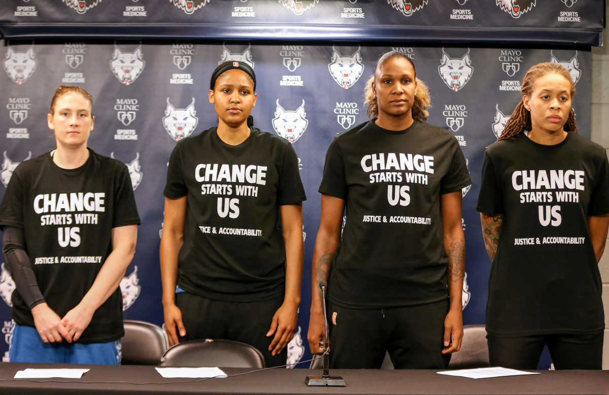 Maya and three other Minnesota Lynx players stand wearing black shirts that say Change starts with us