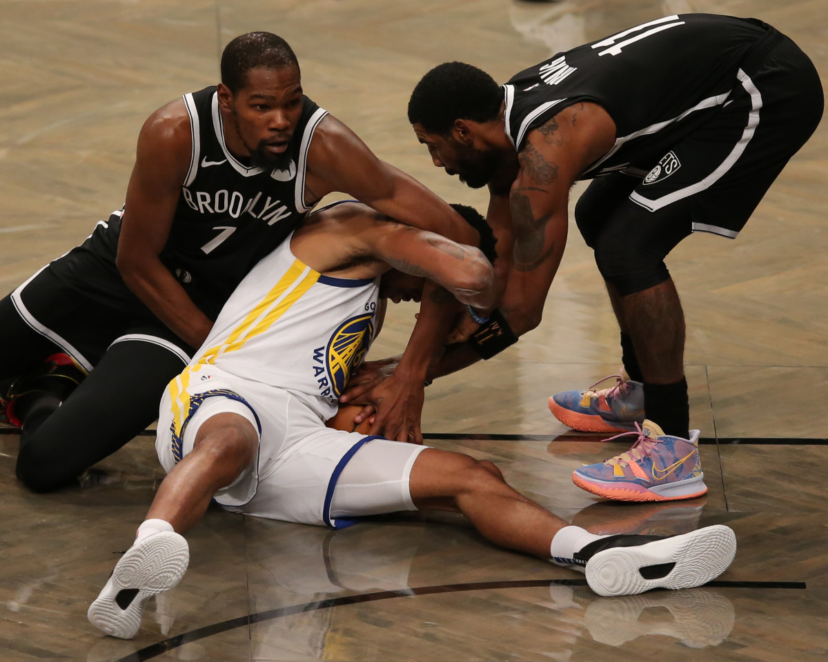 Golden State Warriors shooting guard Kent Bazemore fights for a loose ball against Brooklyn Nets small forward Kevin Durant and point guard Kyrie Irving during the first quarter at Barclays Center.