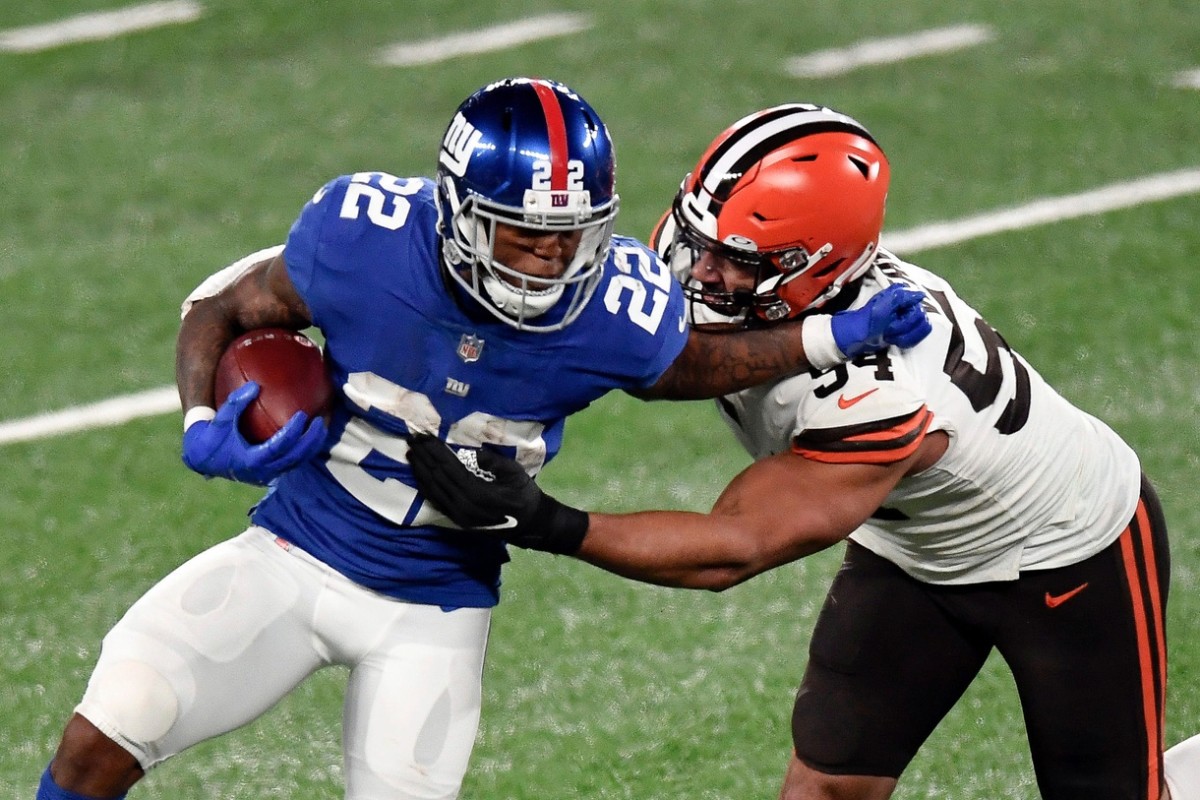 New York Giants running back Wayne Gallman (22) stiff-arms Cleveland Browns defensive end Olivier Vernon (54) in the second half. The Giants lose to the Browns, 20-6, at MetLife Stadium on Sunday, December 20, 2020, in East Rutherford.