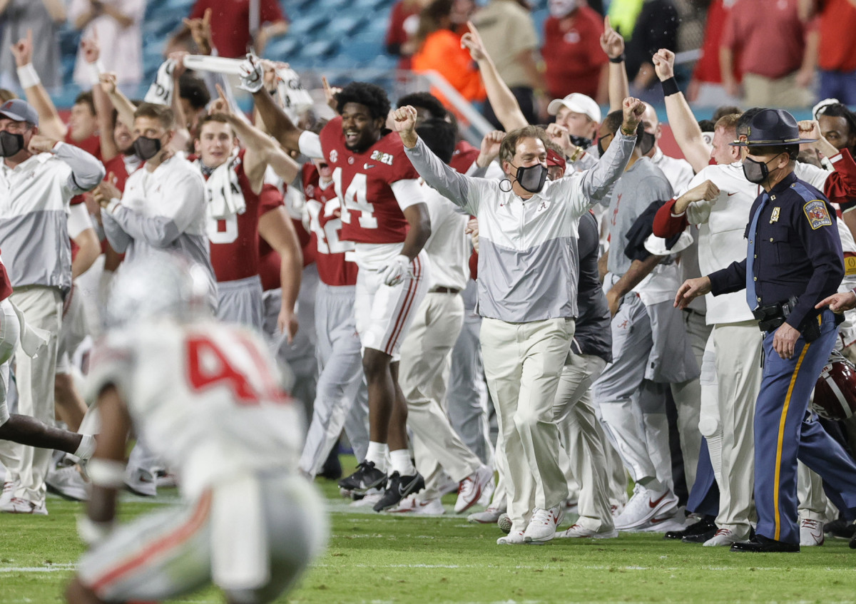 Nick Saban raises his hands in celebration on the sideline