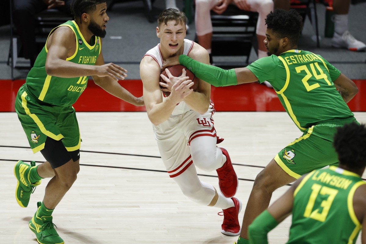 Jan 9, 2021; Salt Lake City, Utah, USA; Utah Utes guard Pelle Larsson (3) tries to get past Oregon Ducks guard LJ Figueroa (12), left and guard Aaron Estrada (24) in the second half at Jon M. Huntsman Center.