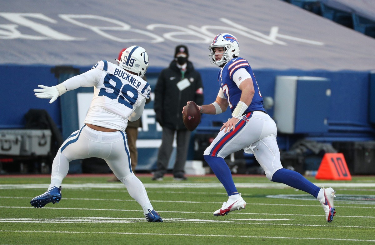 Buffalo Bills quarterback Josh Allen scrambles away from Indianapolis Colts defensive tackle DeForest Buckner in an AFC Wild Card Playoff home win.