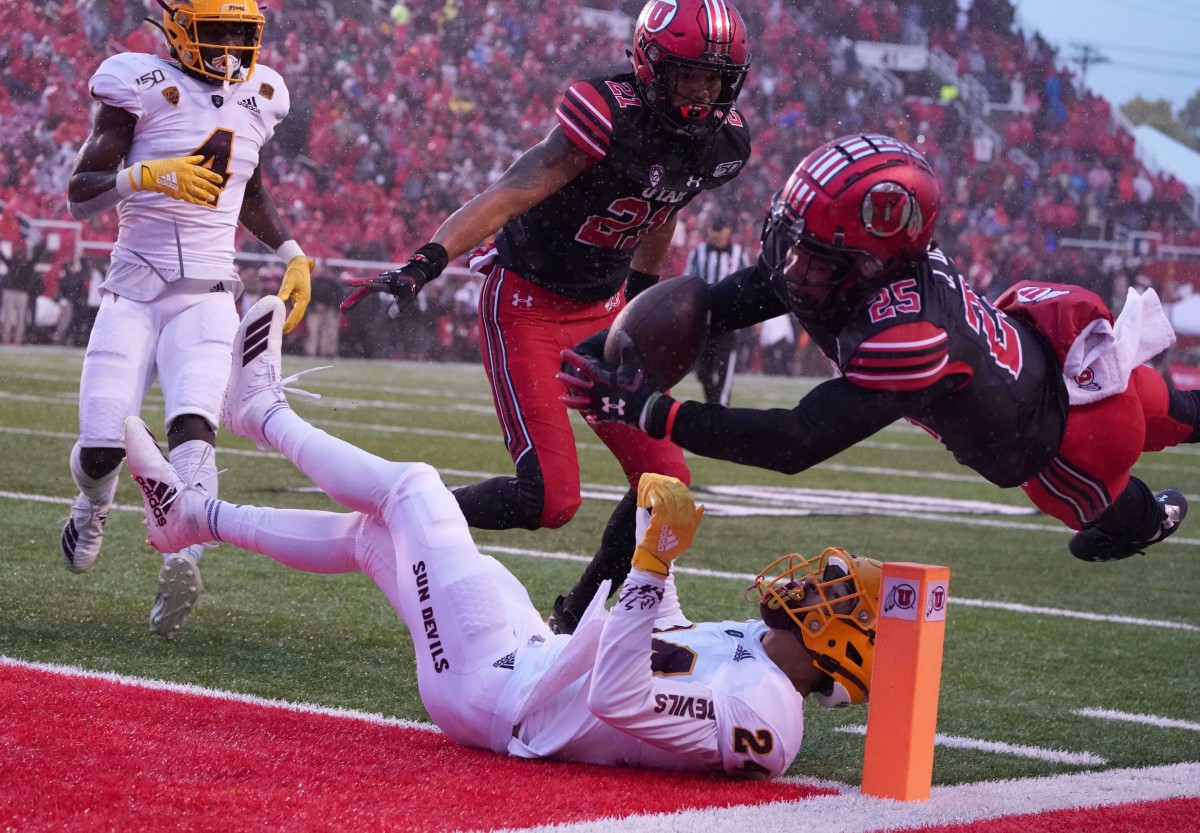 Oct 19, 2019; Salt Lake City, UT, USA; Utah Utes wide receiver Jaylen Dixon (25) leaps over Arizona State Sun Devils defensive back Chase Lucas (24) to score on a touchdown run in the second quarter at Rice-Eccles Stadium.