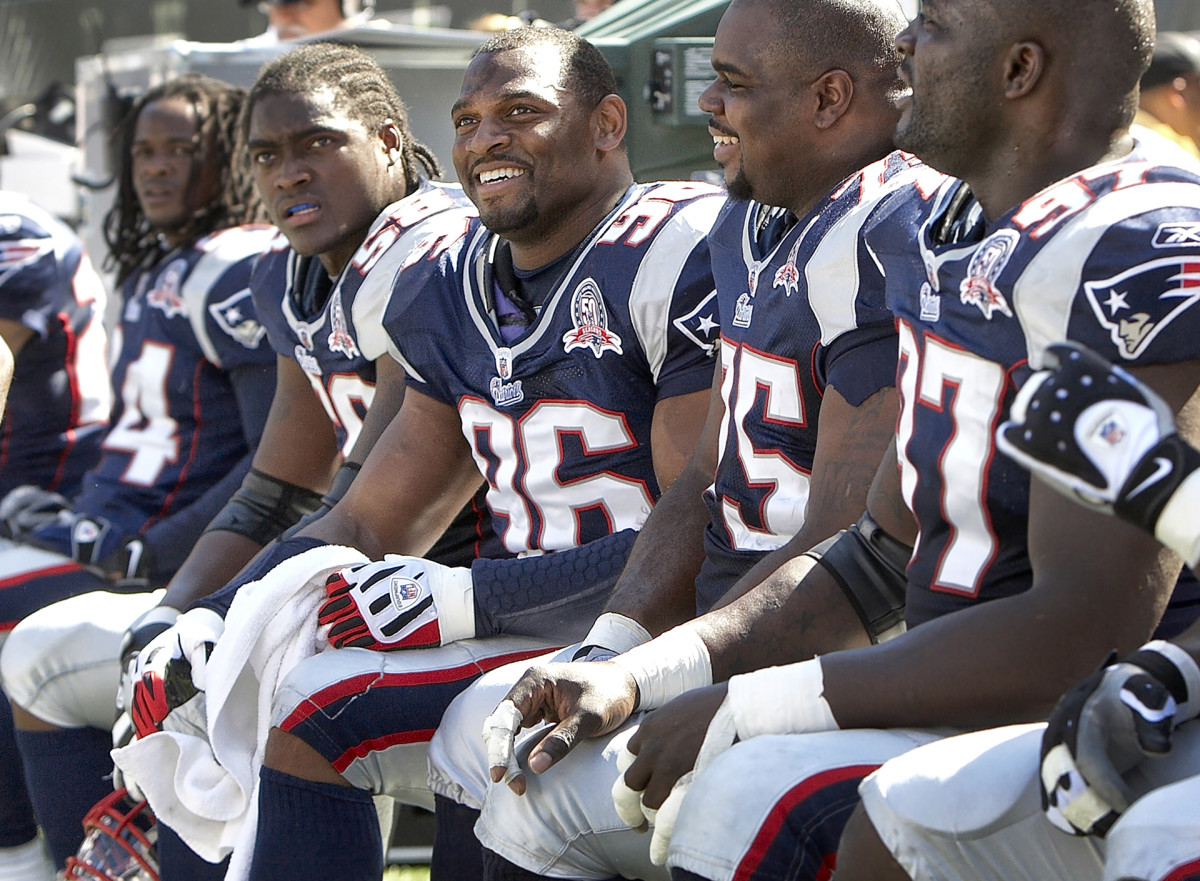 Adalius Thomas and Patriots defensive players on the bench during a game