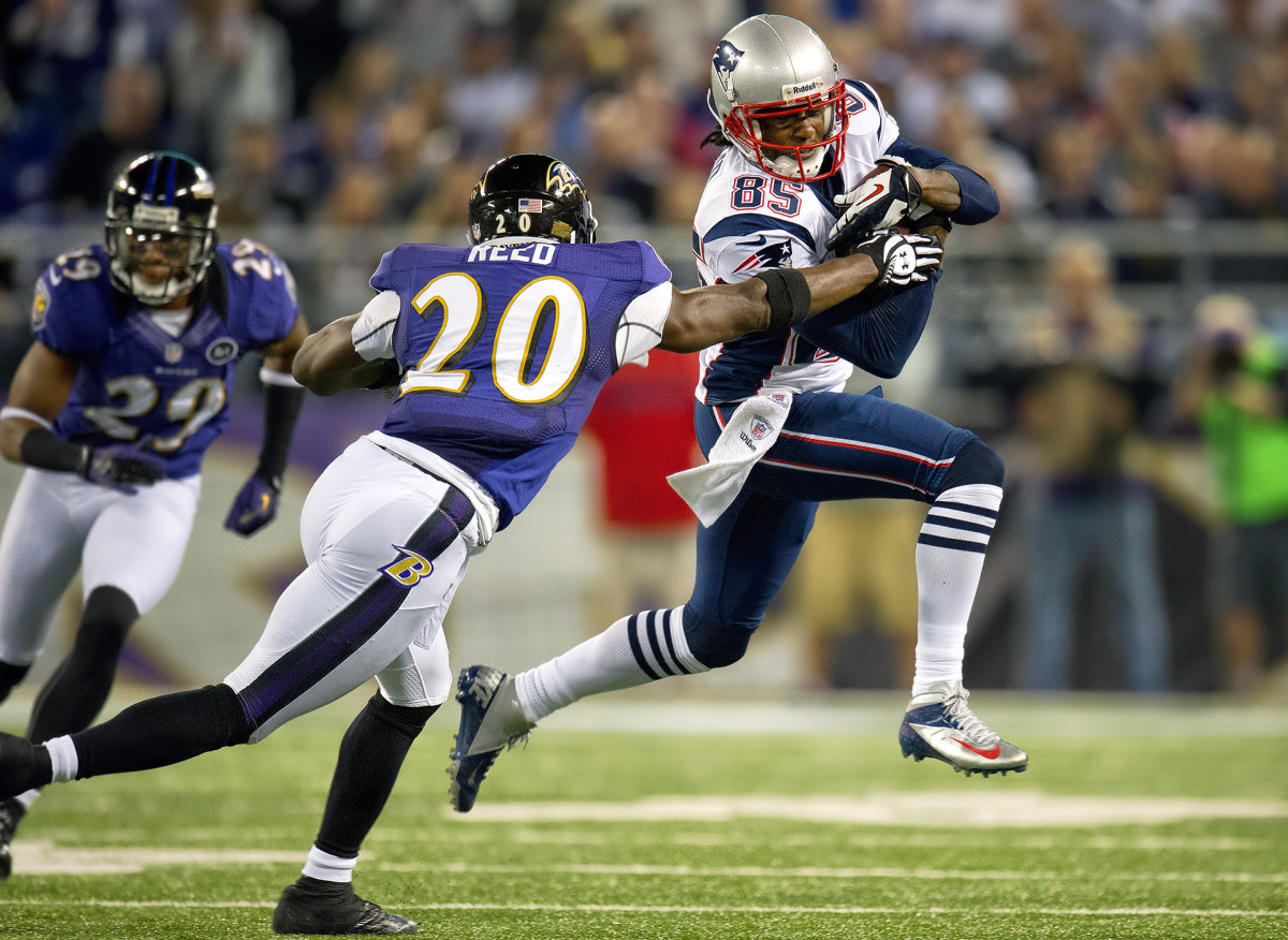 Patriots wide receiver Brandon Lloyd tries to avoid getting tackled by Ravens safety Ed Reed