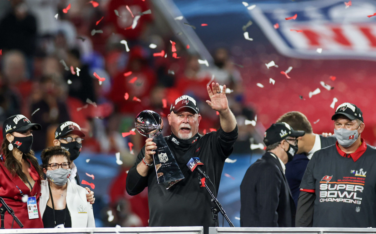 Bucs coach Bruce Arians addresses the crowd from the podium while holding the Lombardi Trophy after Super Bowl LV