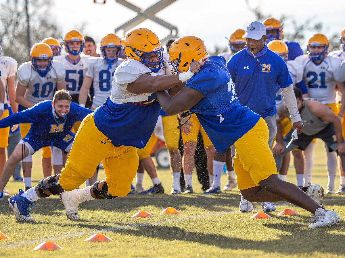 McNeese football players tackle each other during a spring practice