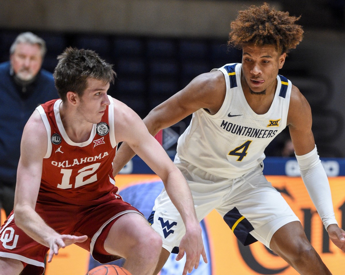 West Virginia guard Miles "Deuce" McBride (4) defends Oklahoma guard Austin Reeves (12) in the Sooners 91-90 double-overtime win over the Mountaineers.