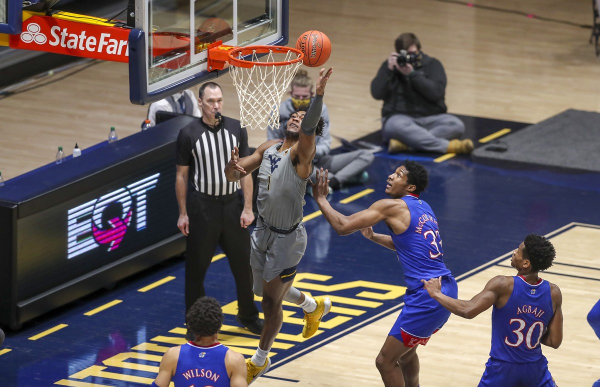 Feb 6, 2021; Morgantown, West Virginia, USA; West Virginia Mountaineers forward Derek Culver (1) shoots along the baseline while guarded by Kansas Jayhawks forward David McCormack (33) during the first half at WVU Coliseum.