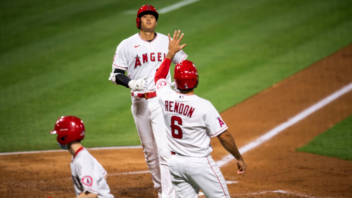 Shohei Ohtani is greeted by Anthony Rendon after scoring a run against the Mariners at Angel Stadium.