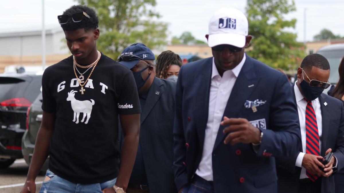 Deion Sanders walks with son Shedeur Sanders ahead of the Hall of Famer's introductory press conference at Jackson State football's head coach