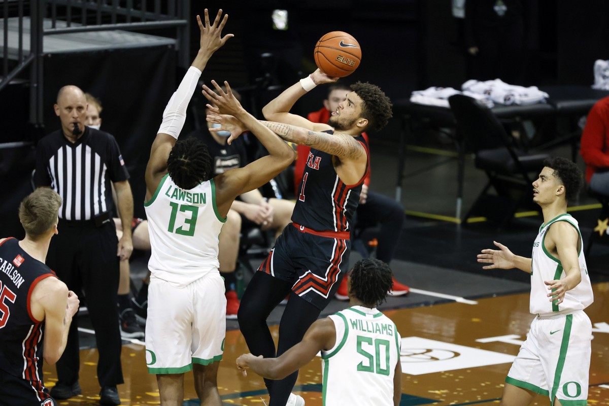 Feb 20, 2021; Eugene, Oregon, USA; Utah Utes forward Timmy Allen (1) shoots the ball over Oregon Ducks forward Chandler Lawson (13) during the second half at Matthew Knight Arena.