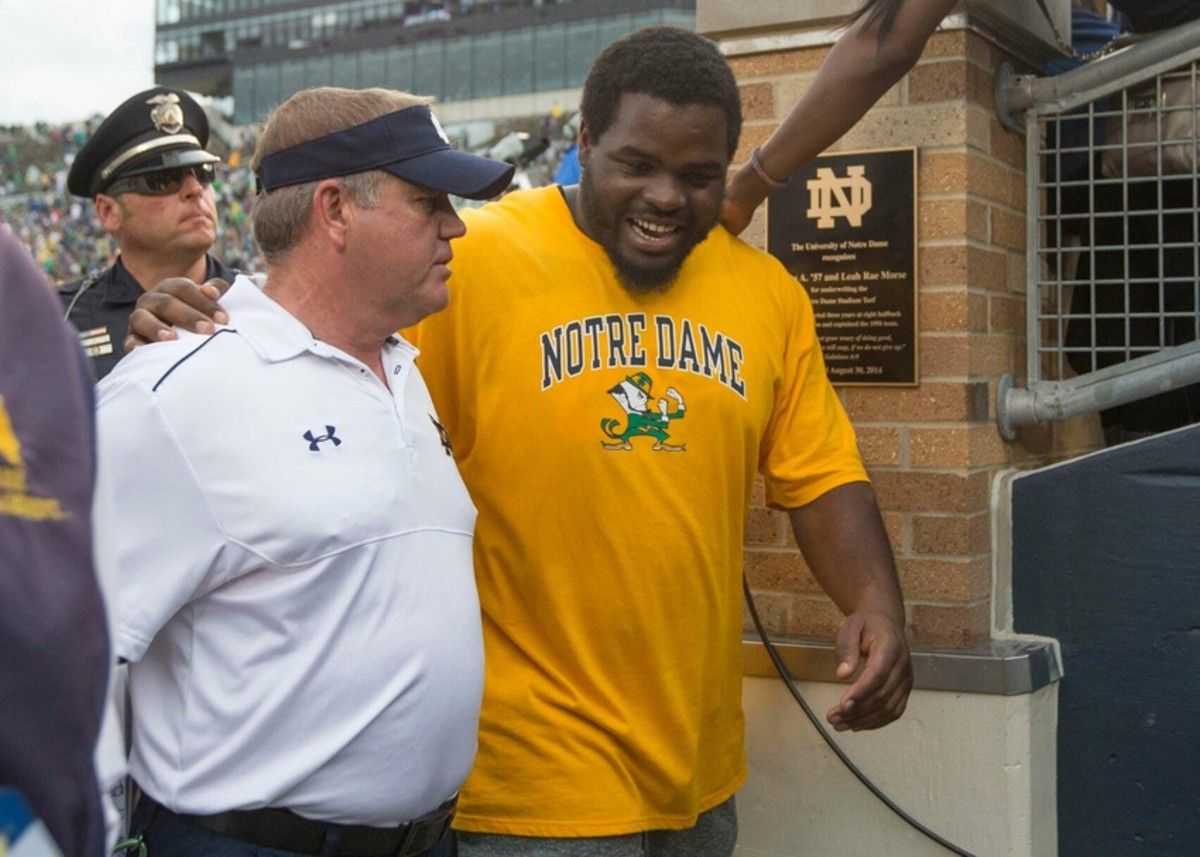 Former Irish nose guard Louis Nix III visits with Notre Dame coach Brian Kelly after Nix attended ND s 2014 season opener with Rice, months after getting drafted by the Houston Texans.