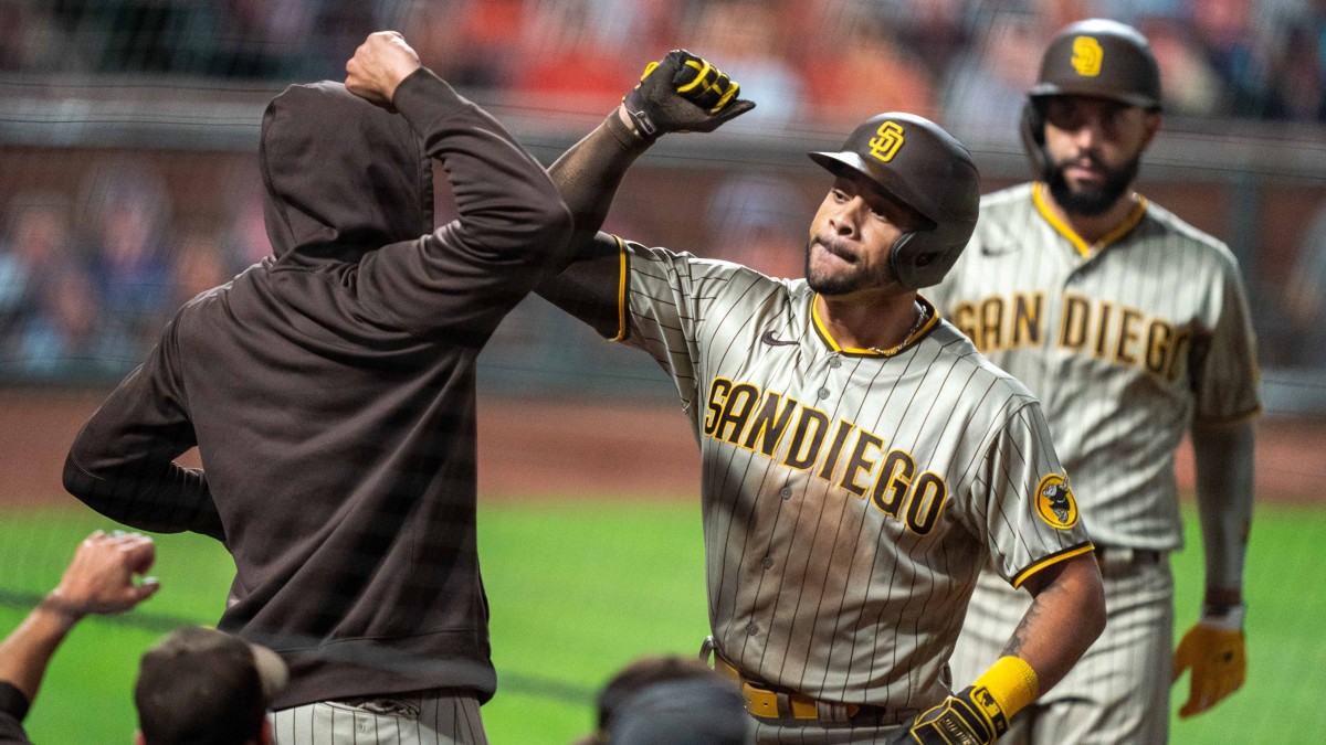Padres' Tommy Pham elbows teammate after scoring a run.