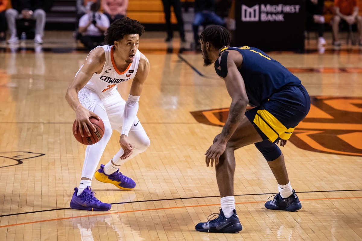Jan 4, 2021; Stillwater, Oklahoma, USA; Oklahoma State Cowboys guard Cade Cunningham (2) dribbles against West Virginia Mountaineers forward Derek Culver (1) during the second half at Gallagher-Iba Arena.
