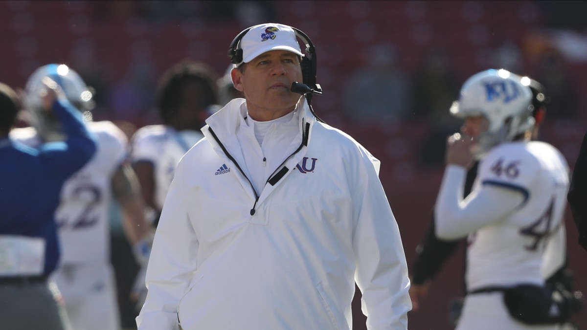 Les Miles walks the Kansas sideline prior to kickoff