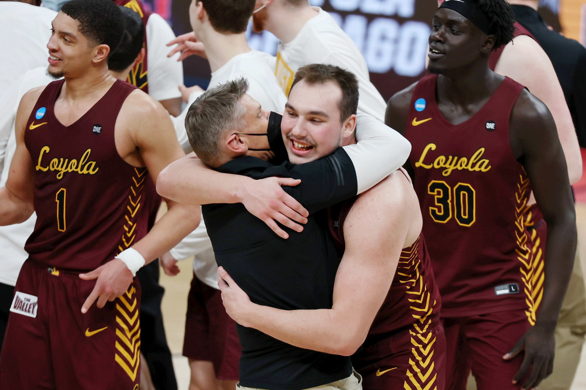 Loyola Ramblers center Cameron Krutwig (25) hugs head coach Porter Moser after their win over the Illinois Fighting Illini in the second round of the 2021 NCAA Tournament at Bankers Life Fieldhouse. The Loyola Ramblers won 71-58.