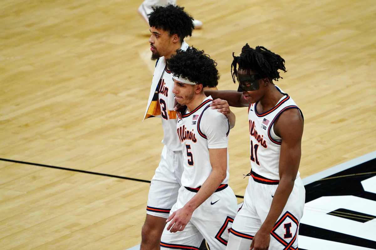 Illinois Fighting Illini guard Jacob Grandison (3) and guard Andre Curbelo (5) and guard Ayo Dosunmu (11) walk off the court after their loss to the Loyola Ramblers in the second round of the 2021 NCAA Tournament at Bankers Life Fieldhouse. The Loyola Ramblers won 71-58.