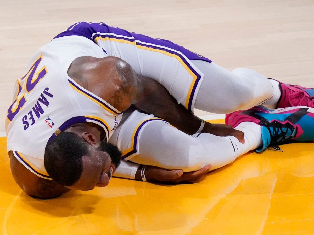 LeBron James grabs his ankle after injuring it