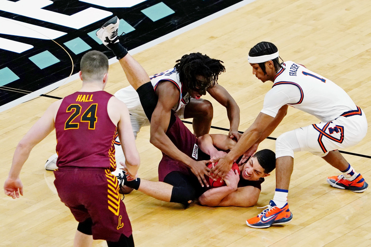 Illinois Fighting Illini guard Ayo Dosunmu (left) and guard Trent Frazier (right) and Loyola Ramblers guard Lucas Williamson (1) battle for a loose ball during the second half in the second round of the 2021 NCAA Tournament at Bankers Life Fieldhouse. The Loyola Ramblers won 71-58.