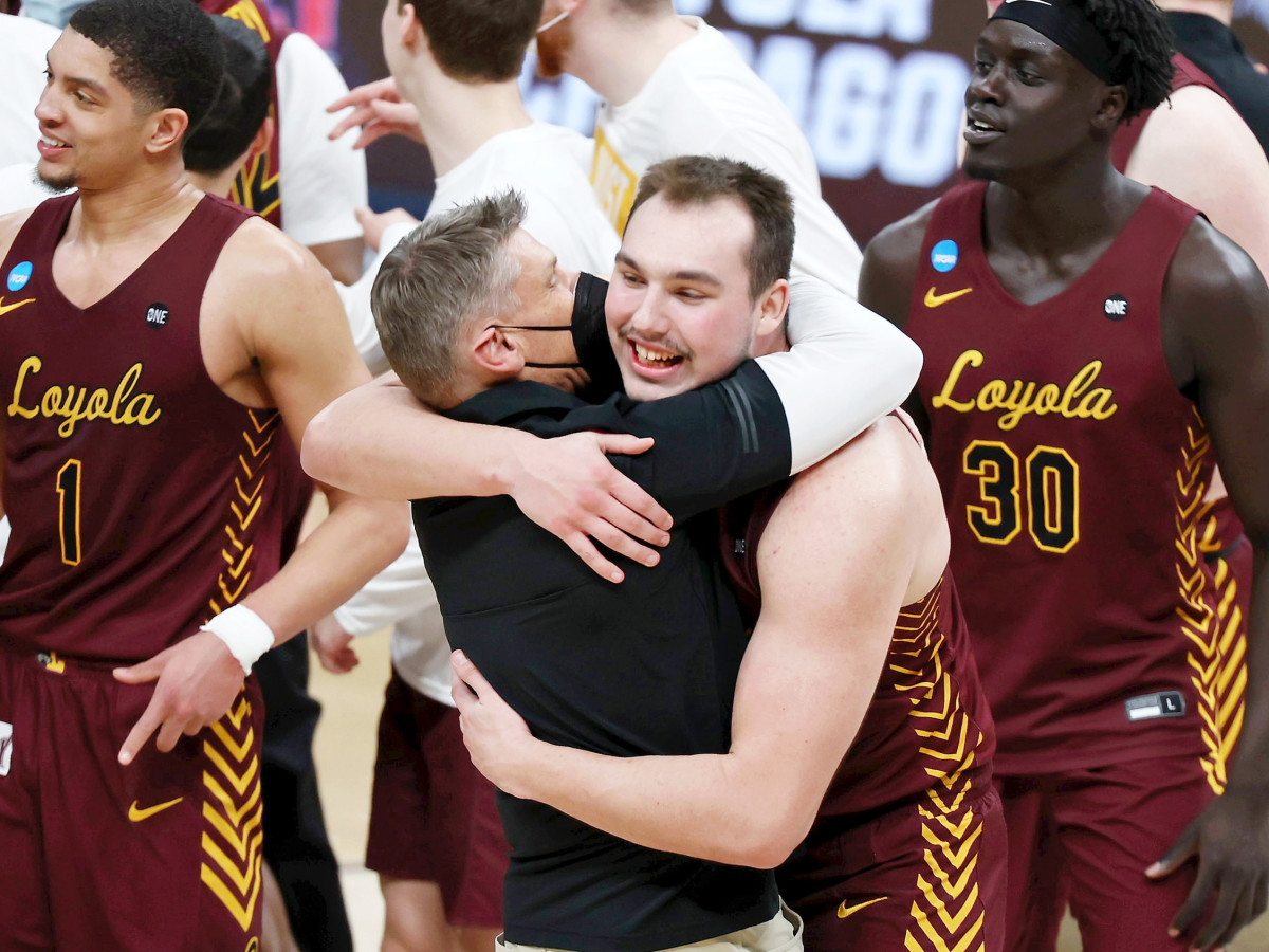 Mar 21, 2021; Indianapolis, Indiana, USA; Loyola Ramblers center Cameron Krutwig (25) hugs head coach Porter Moser after their win over the Illinois Fighting Illini in the second round of the 2021 NCAA Tournament at Bankers Life Fieldhouse. The Loyola Ramblers won 71-58.