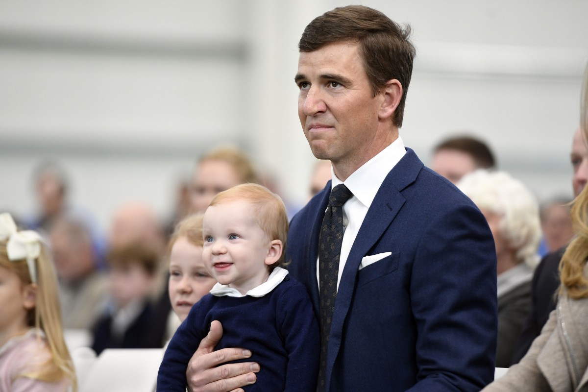 Jan 24, 2020; East Rutherford, New Jersey, USA; New York Giants quarterback Eli Manning holds his son Charlie as he watches a tribute video made of his career at Quest Diagnostics Training Center.