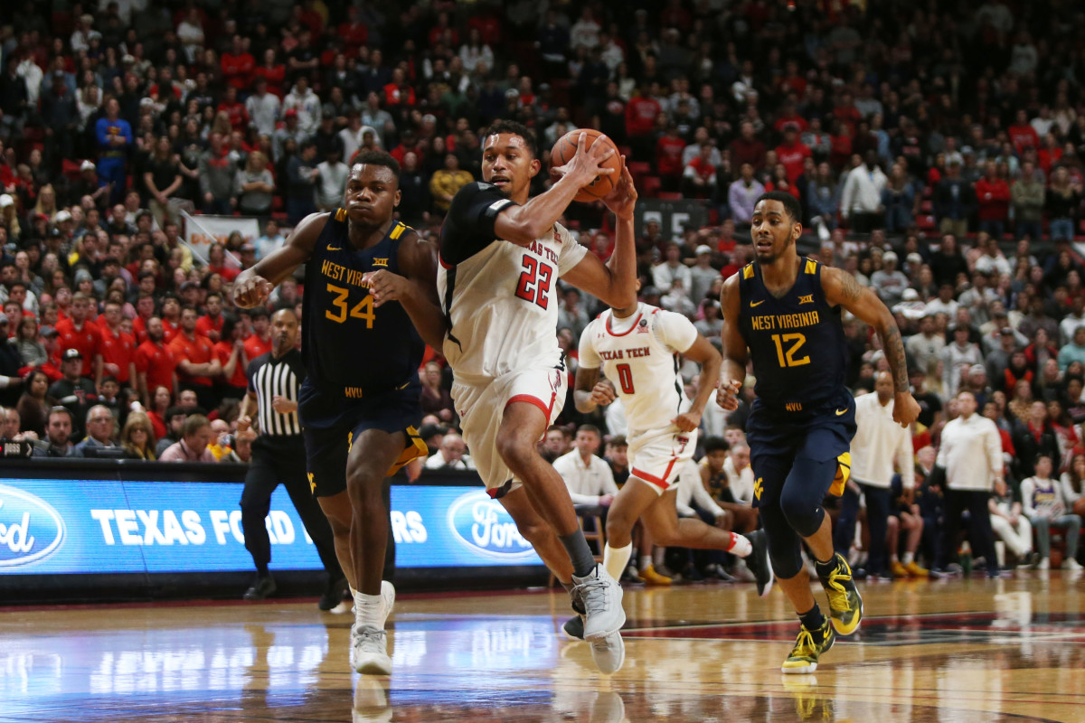 Jan 29, 2020; Lubbock, Texas, USA; Texas Tech Red Raiders forward TJ Holyfield (22) races down court in front of West Virginia Mountaineers forward Oscar Tshiebwe (34) and guard Taz Sherman (12) in the second half at United Supermarkets Arena.