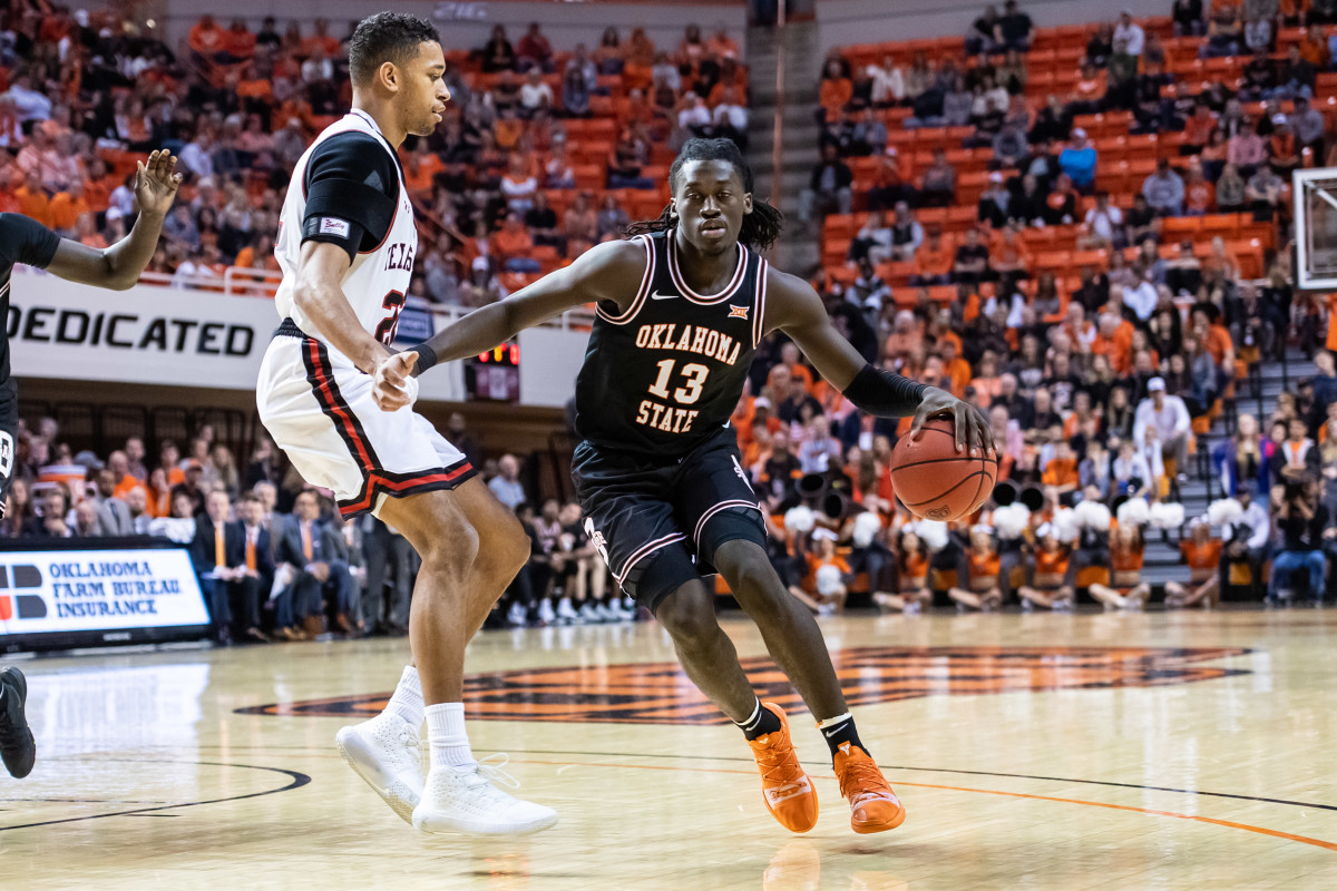 Oklahoma State point guard Isaac Likekele dribbles in the first half in the classic Oklahoma State uniform from 1994-95.