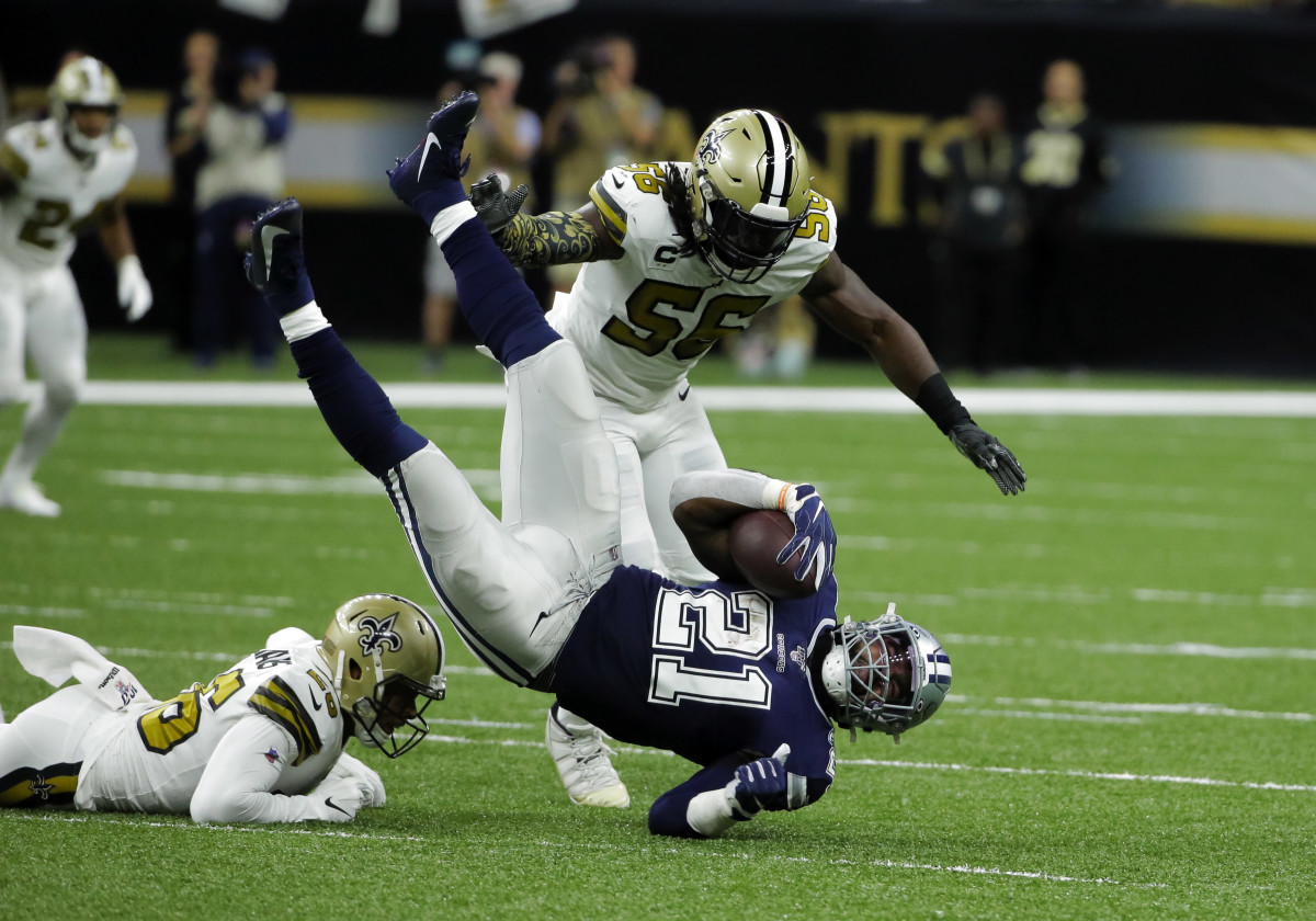 Sep 29, 2019; New Orleans, LA, USA; Dallas Cowboys running back Ezekiel Elliott (21) is upended by New Orleans Saints cornerback P.J. Williams (26) and outside linebacker Demario Davis (56) during the first quarter at the Mercedes-Benz Superdome. Mandatory Credit: Derick E. Hingle-USA TODAY Sports