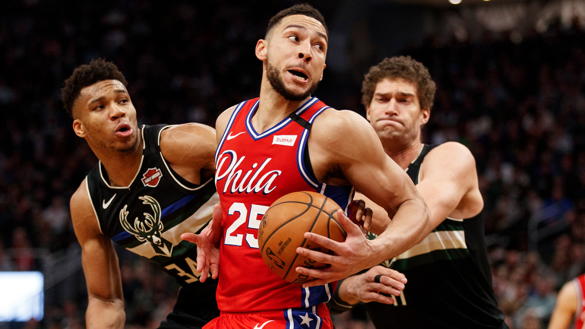 Ben Simmons spins to the basket against Milwaukee Bucks forward Giannis Antetokounmpo and center Brook Lopez