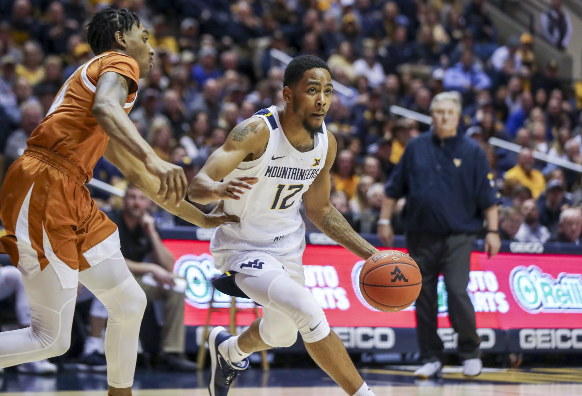 West Virginia Mountaineers guard Taz Sherman (12) dribbles past Texas Longhorns guard Donovan Williams (4) during the second half at WVU Coliseum.
