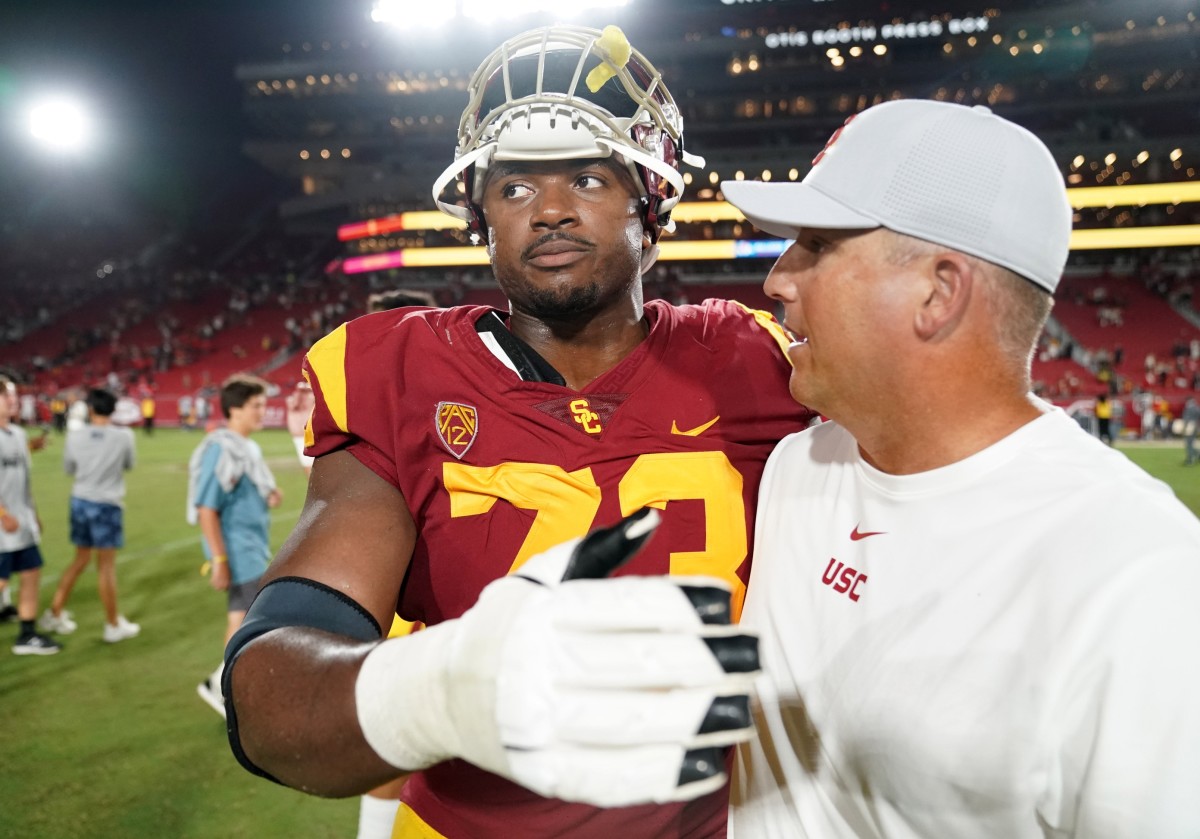 Aug 31, 2019; Los Angeles, CA, USA; Southern California Trojans head coach Clay Helton (right) and offensive tackle Austin Jackson (73) embrace after the game against the Fresno State Bulldogs at Los Angeles Memorial Coliseum. USC defeated Fresno State 31-23.