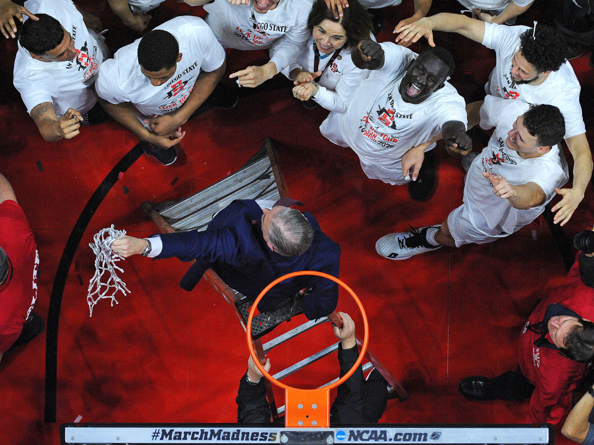 San Diego State head coach Brian Dutcher holds the net after defeating New Mexico and clinching a share of the Mountain West regular season title at Viejas Arena.