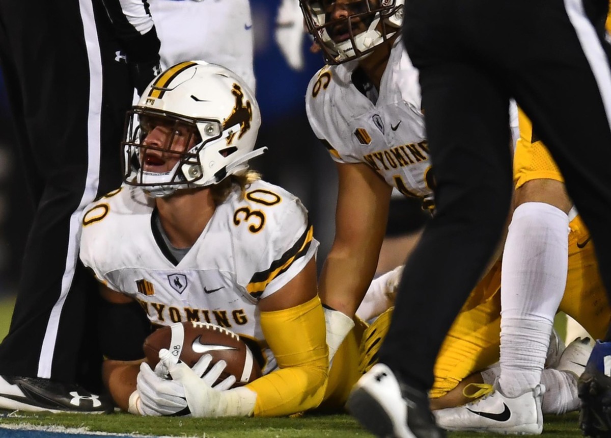 Wyoming Cowboys linebacker Logan Wilson (30) recovers a fumble in the second quarter against the Air Force Falcons at Falcon Stadium.