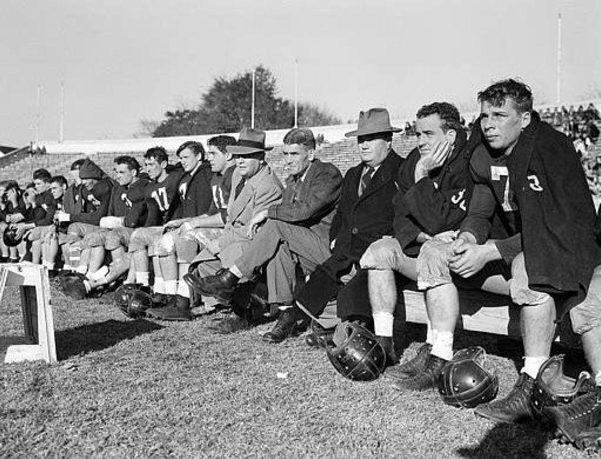 Hank Crisp, between Tilden Campbell and Frank Thomas (in hats)  during the Alabama vs Pensacola Naval Air Base game in 1945