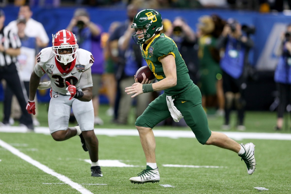 Jan 1, 2020; New Orleans, Louisiana, USA; Baylor Bears quarterback Charlie Brewer (12) runs from pressure by the Georgia Bulldogs linebacker Tae Crowder (30) in the second half of the Sugar Bowl at the Mercedes-Benz Superdome.