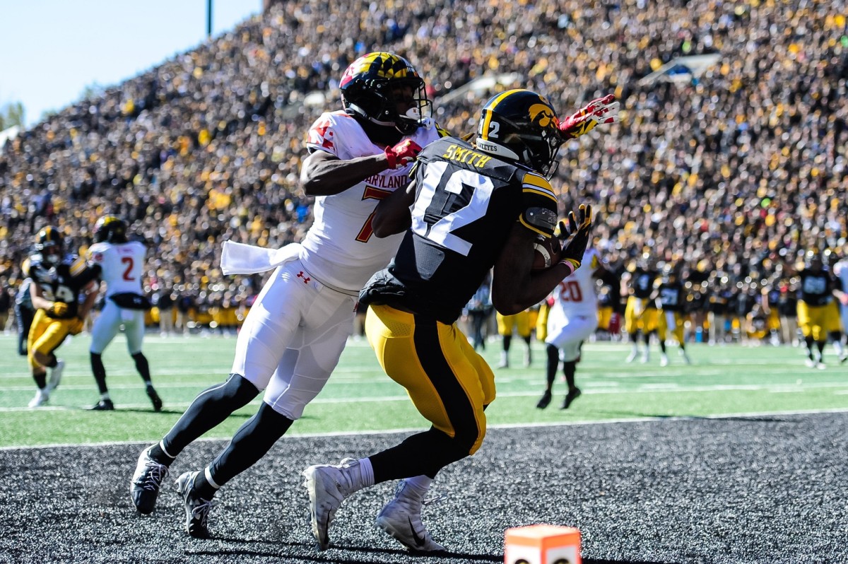Oct 20, 2018; Iowa City, IA, USA; Iowa Hawkeyes wide receiver Brandon Smith (12) catches a touchdown pass from quarterback Nate Stanley (not pictured) as Maryland Terrapins defensive back Tino Ellis (7) defends during the second quarter at Kinnick Stadium. Mandatory Credit: Jeffrey Becker-USA TODAY Sports