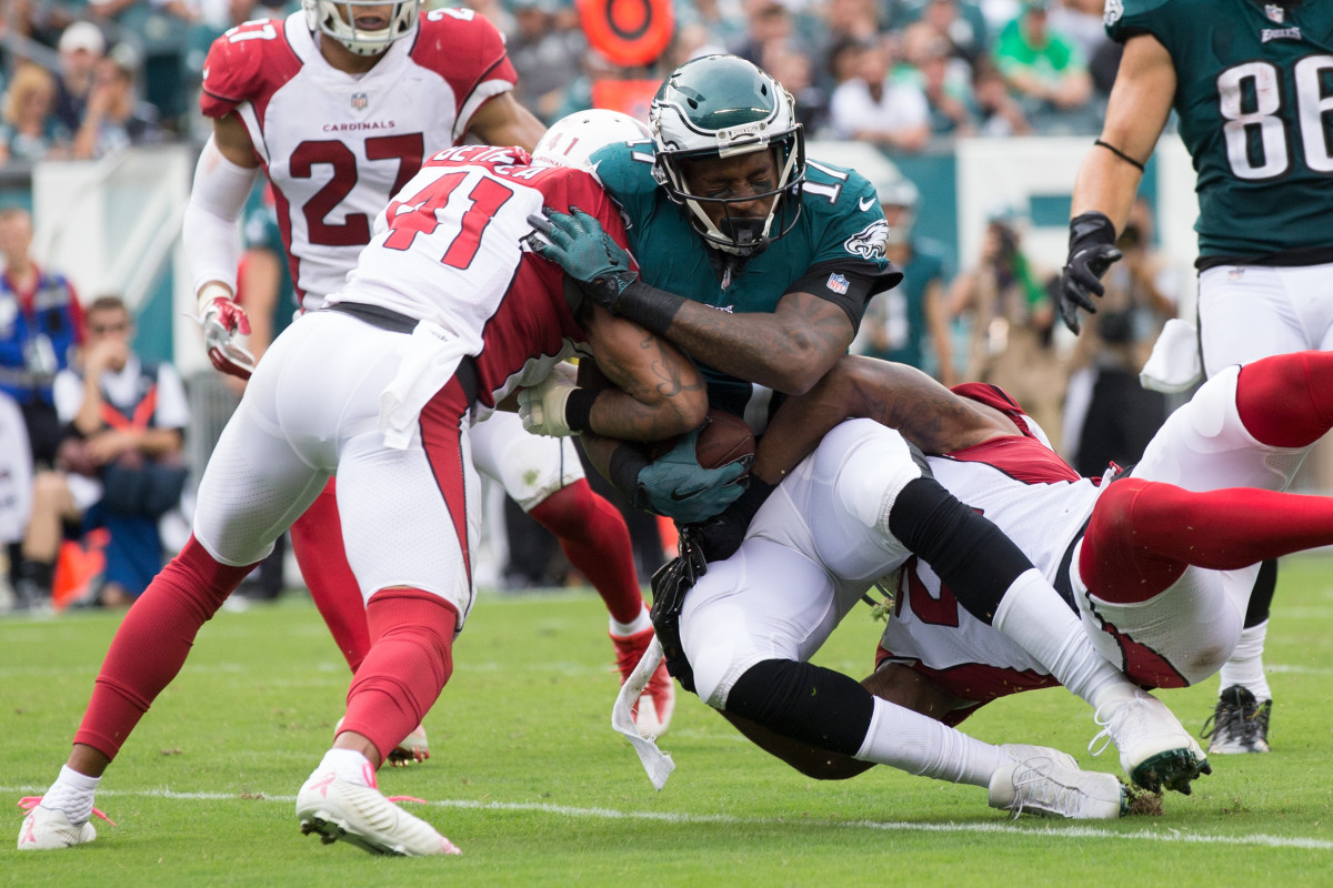 Eagles wide receiver Alshon Jeffery is tackled by Cardinals cornerback Patrick Peterson and strong safety Antoine Bethea during a 2017 game. The Cardinals and Eagles have been rivals since the late 1940s.