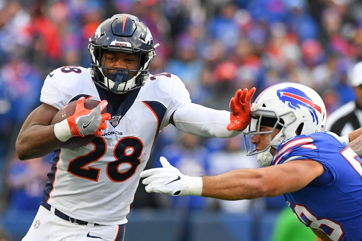 Denver Broncos running back Royce Freeman (28) runs with the ball as Buffalo Bills outside linebacker Matt Milano (58) defends during the third quarter at New Era Field.