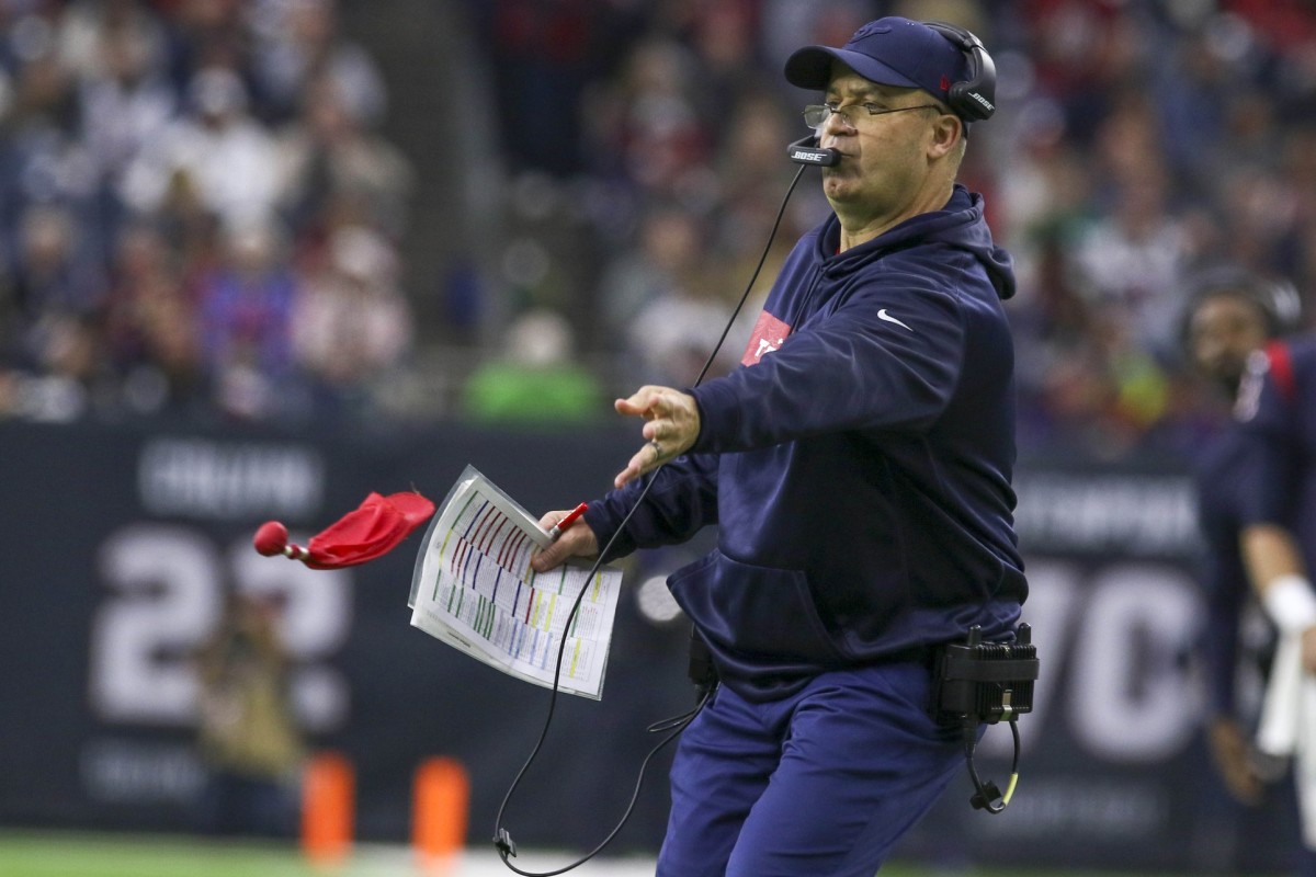 Houston Texans coach Bill O'Brien throws his red flag to challenge a call during a 2019 game.