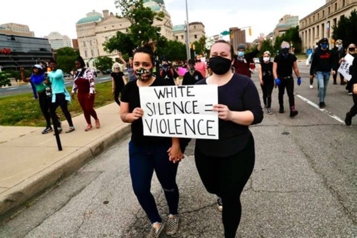 Two peaceful protestors hold up a sign during a march in Indianapolis on Monday.