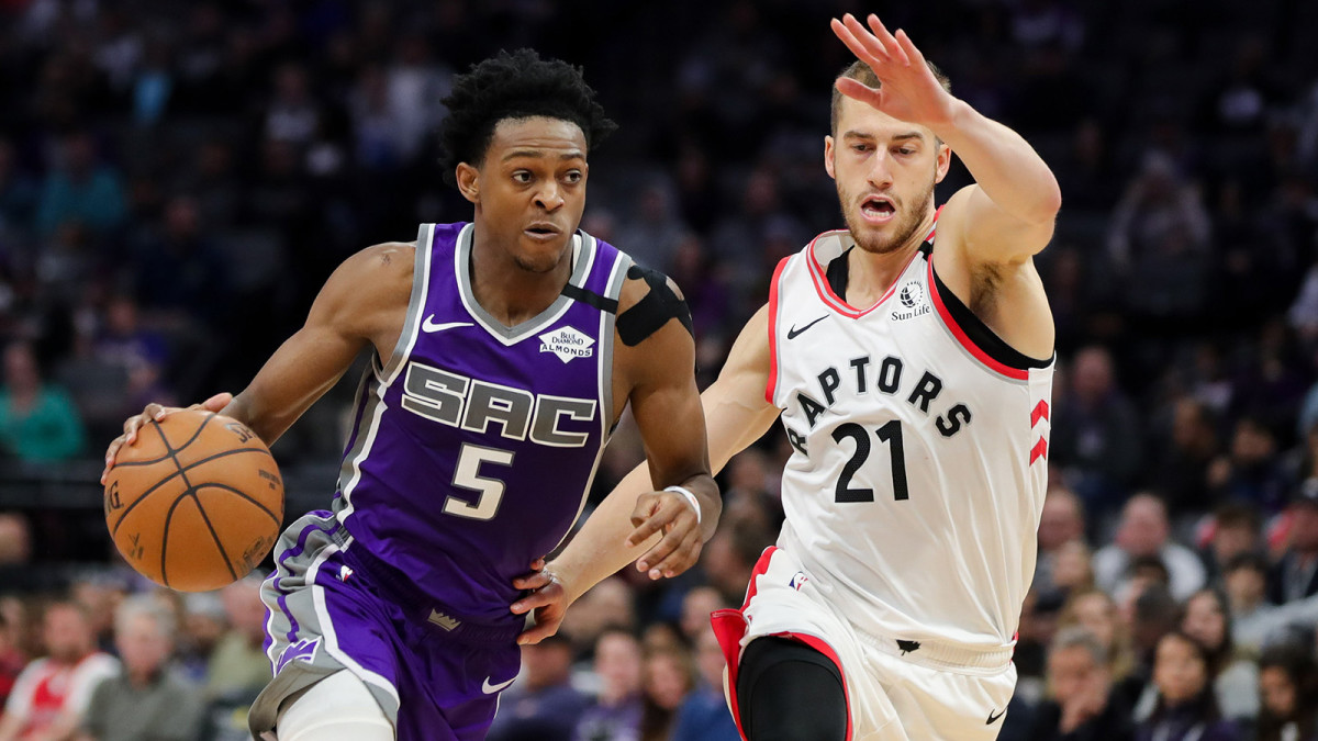 De'Aaron Fox dribbles the ball past Toronto Raptors guard Matt Thomas